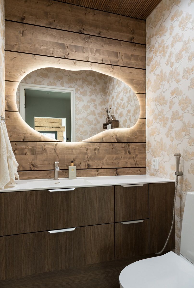 Backlit cloud-shaped form mirror complements the lighting in the toilet